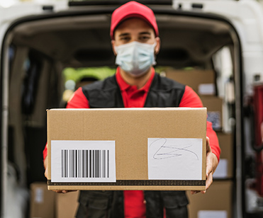 a truck driver/delivery man holding a box